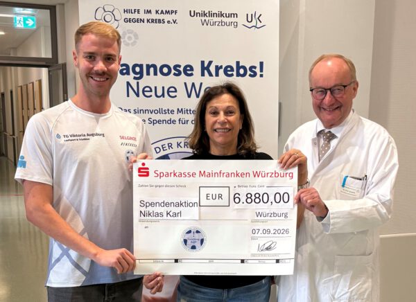 Bei der Spendenübergabe am Uniklinikum Würzburg (von links): Triathlet Niklas Karl mit Gabriele Nelkenstock und Prof. Dr. Hermann Einsele, beide von der Stiftung „Forschung hilft“. © Samantha Baumeister / UKW