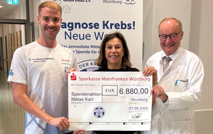 Bei der Spendenübergabe am Uniklinikum Würzburg (von links): Triathlet Niklas Karl mit Gabriele Nelkenstock und Prof. Dr. Hermann Einsele, beide von der Stiftung „Forschung hilft“. © Samantha Baumeister / UKW